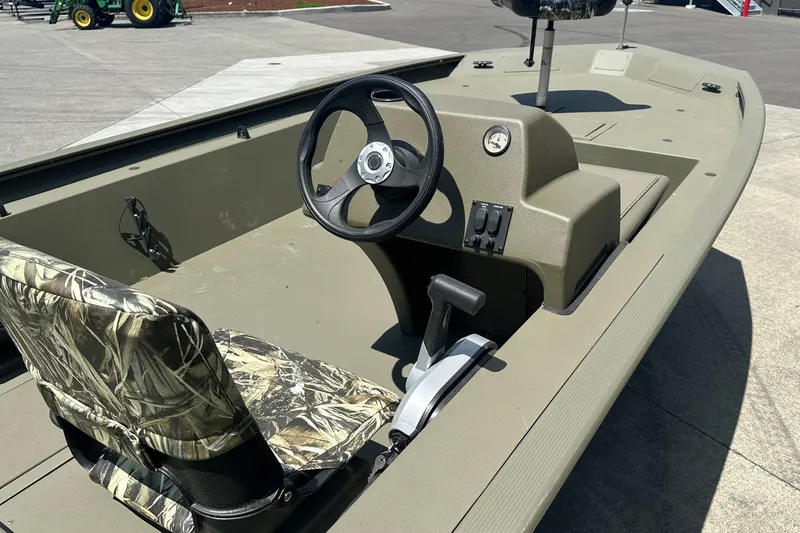 The Image of 2026 Tracker Grizzly 1754 SC boat on trailer, outdoors, surrounded by trees. - 0