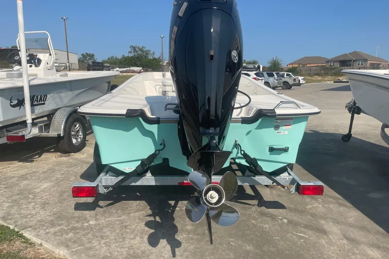 Slide: The Image of 2026 Mako Pro Skiff 17 CC boat on trailer, rear view, outdoor setting. - 4