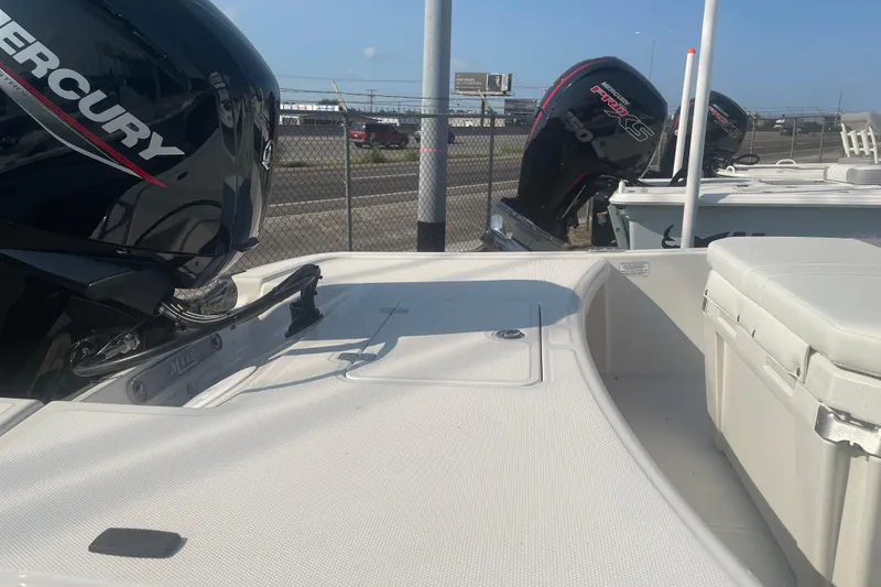 Slide: The Image of 2026 Mako Pro Skiff 17 CC boat with Mercury engine, docked outdoors. - 6
