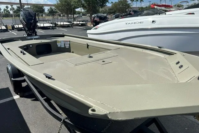 Slide: The Image of 2026 Tracker Grizzly 1654 T Sportsman boat in a parking lot, side view. - 5