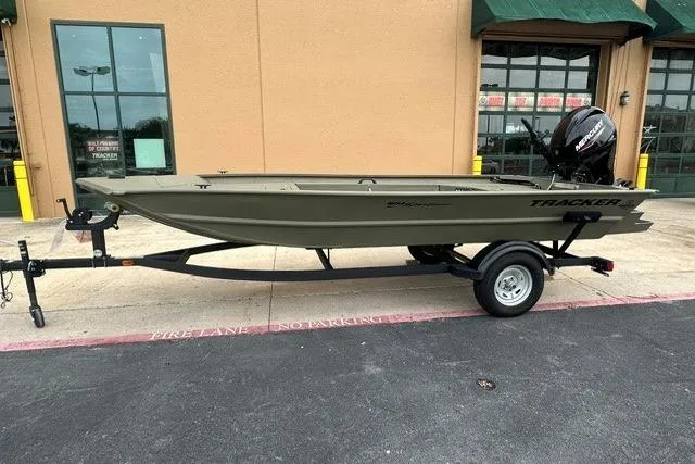 The Image of 2026 Tracker Grizzly 1654 T Sportsman boat on trailer outside a building. - 0