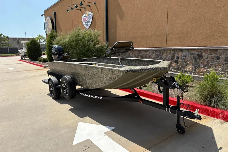 Slide: The Image of 2026 Tracker Grizzly 1650 T Prairie Wings Edition boat on trailer, parked outdoors. - 2