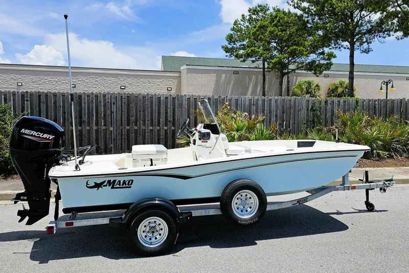 Slide: The Image of 2026 Mako Pro Skiff 15 CC boat on trailer, parked outdoors. - 0