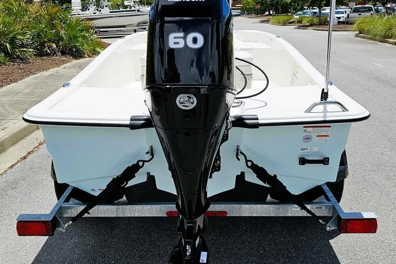 Slide: The Image of 2026 Mako Pro Skiff 15 CC with 60 HP engine on trailer, parked outdoors. - 3