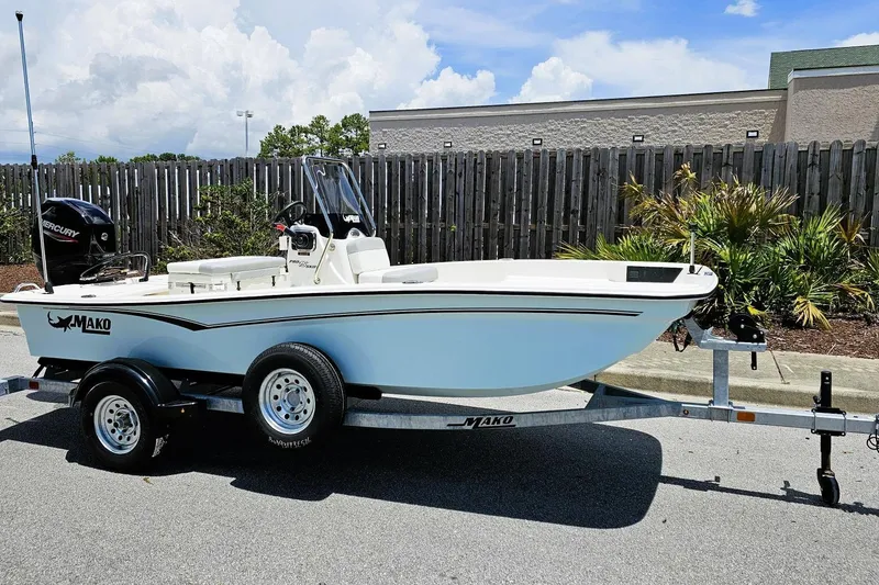 Slide: The Image of 2026 Mako Pro Skiff 15 CC boat on trailer, parked outdoors under clear sky. - 4