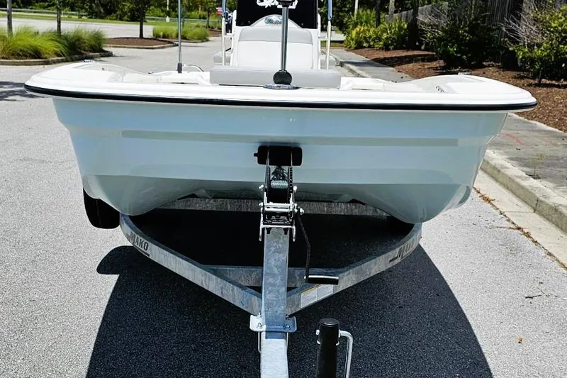 Slide: The Image of 2026 Mako Pro Skiff 15 CC boat on trailer, parked in a sunny outdoor setting. - 7