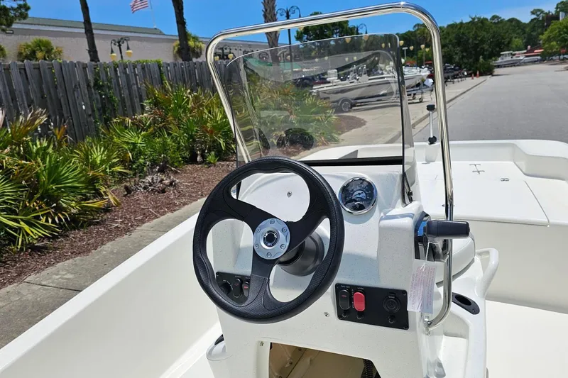 Slide: The Image of 2026 Mako Pro Skiff 15 CC boat console with steering wheel and controls. - 9