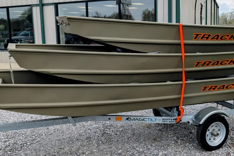 The Image of 2026 Tracker Grizzly 14 Jon boats stacked on trailer outside a building. - 1
