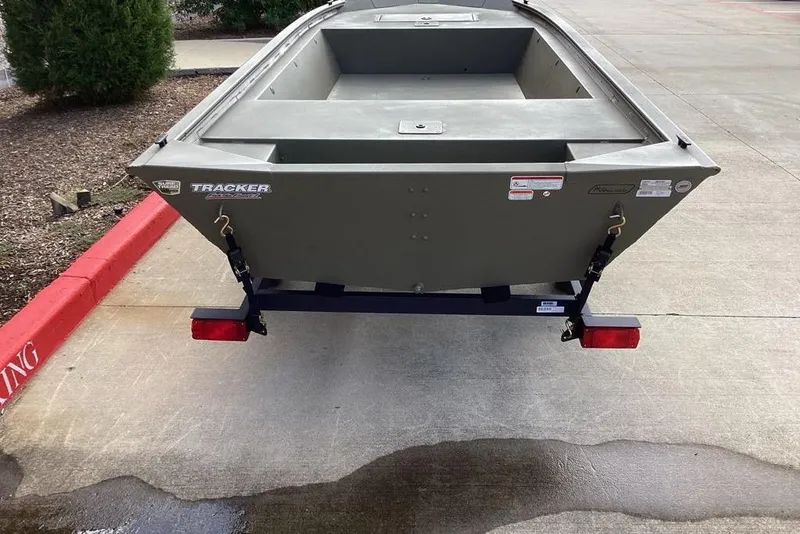 Slide: The Image of 2026 Tracker Grizzly 1648 Utility boat on trailer, parked on concrete surface. - 2