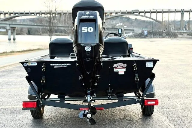 Slide: The Image of 2026 Tracker Bass Tracker Classic XL boat with Mercury engine, parked near a bridge. - 76