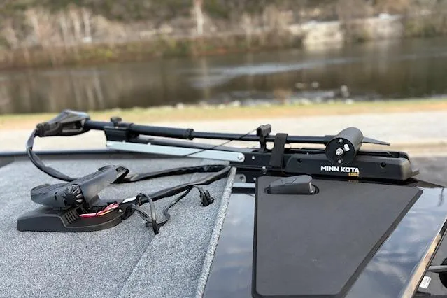 Slide: The Image of 2026 Tracker Bass Tracker Classic XL with Minn Kota trolling motor by a lake. - 78