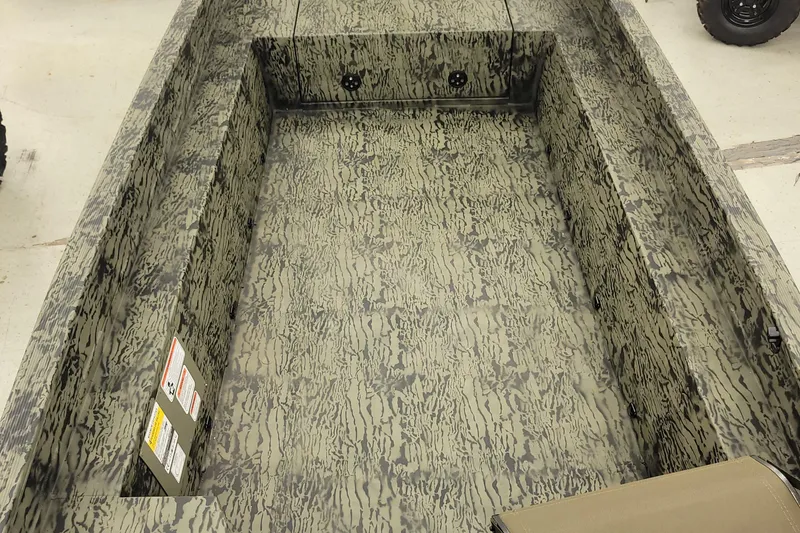 Slide: The Image of 2026 Tracker Grizzly 1650 T Prairie Wings Edition boat interior with camouflage design. - 2