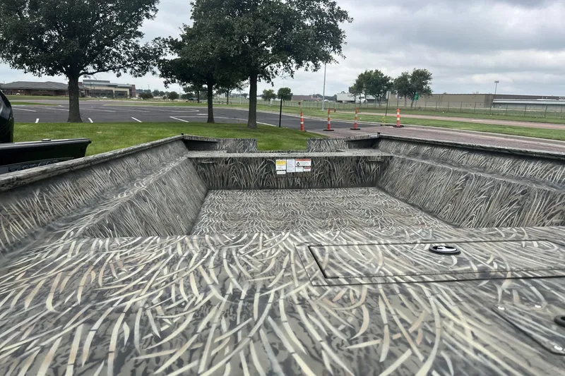 Slide: The Image of 2026 Tracker Grizzly 2072 Utility boat with camouflage interior, parked outdoors. - 3