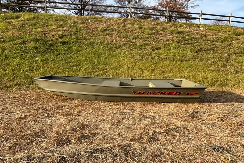 The Image of 2026 Tracker Grizzly 12 Jon boat on grassy terrain, side view. - 0