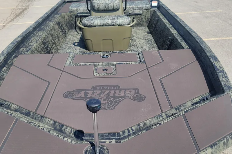 Slide: The Image of 2026 Tracker Grizzly 1860 CC boat interior with camo design and seating. - 2