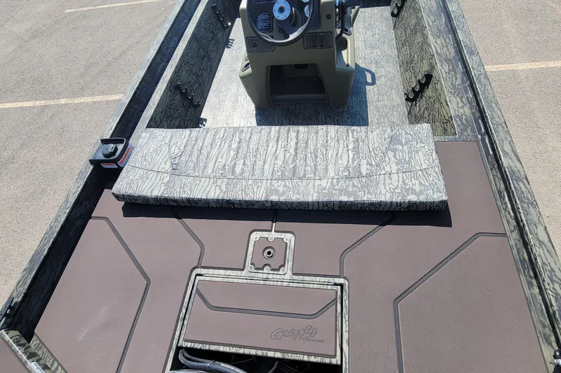Slide: The Image of 2026 Tracker Grizzly 1860 CC boat interior with camouflage design and steering console. - 3