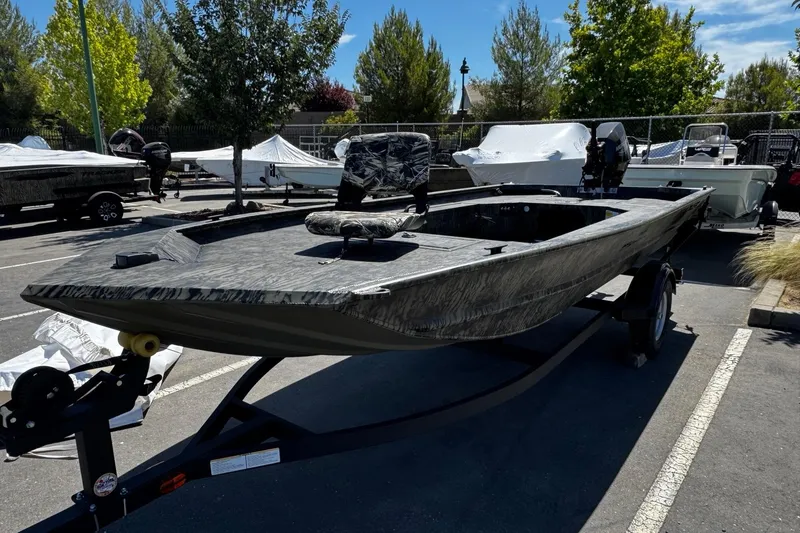The Image of 2026 Tracker Grizzly 1654 T Sportsman boat on trailer in parking lot. - 0