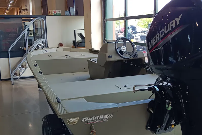 Slide: The Image of 2026 Tracker Grizzly 1648 SC boat displayed indoors, showcasing its sleek design and sturdy build. - 5