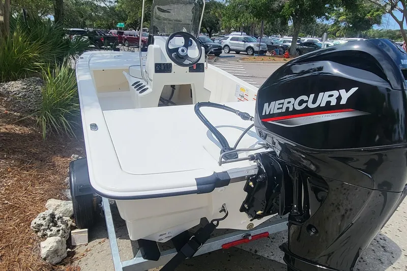 Slide: The Image of 2026 Mako Pro Skiff 13 CC boats displayed at a dealership under clear blue skies. - 2