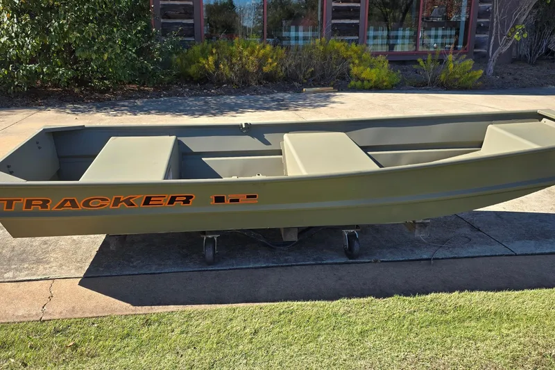 Slide: The Image of 2026 Tracker Grizzly 12 Jon boat on display outdoors, showcasing its sturdy design. - 2