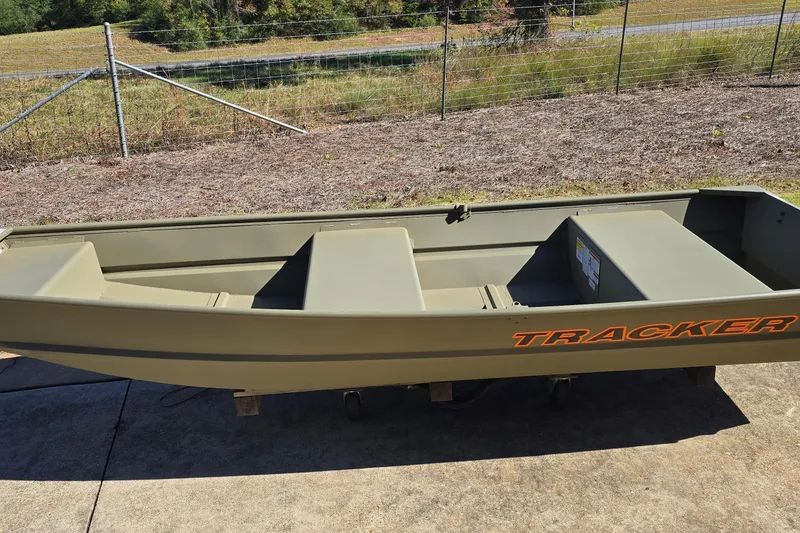 Slide: The Image of 2026 Tracker Grizzly 12 Jon boat on concrete, with grassy background. - 6