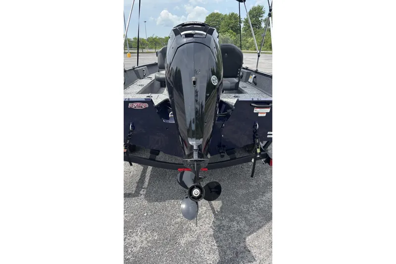 Slide: The Image of 2026 Tracker Pro Guide V-16 SC boat with outboard motor in parking lot. - 4