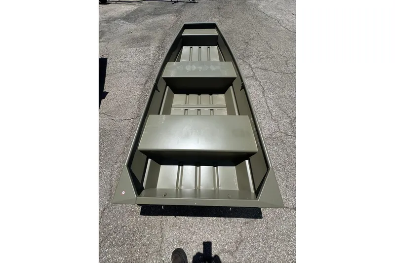 Slide: The Image of 2026 Tracker Grizzly 12 Jon boat on pavement, showcasing interior seating and structure. - 2
