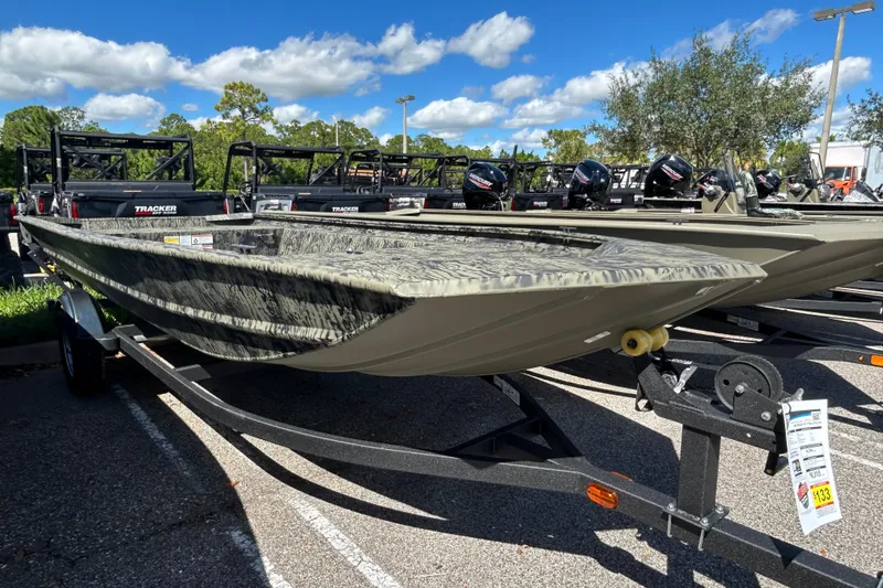 The Image of 2026 Tracker Grizzly 1754 Utility boat on trailer, parked outdoors under blue sky. - 0