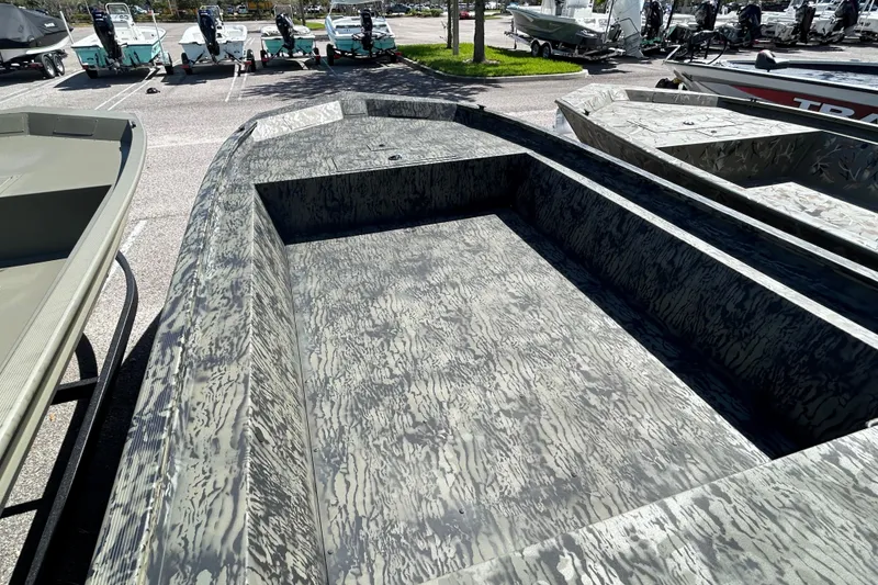 Slide: The Image of 2026 Tracker Grizzly 1754 Utility boat with camouflage pattern in a parking lot. - 2