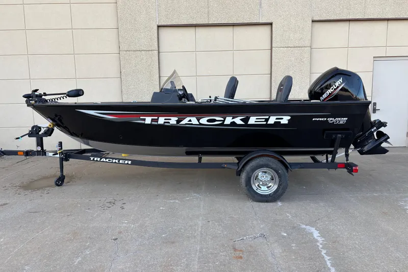 Slide: The Image of 2026 Tracker Pro Guide V-16 SC boat on trailer, black exterior, parked outdoors. - 75