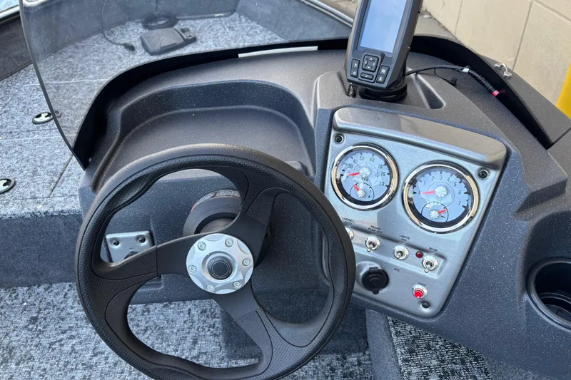 Slide: The Image of 2026 Tracker Pro Guide V-16 SC boat dashboard with steering wheel and gauges. - 77