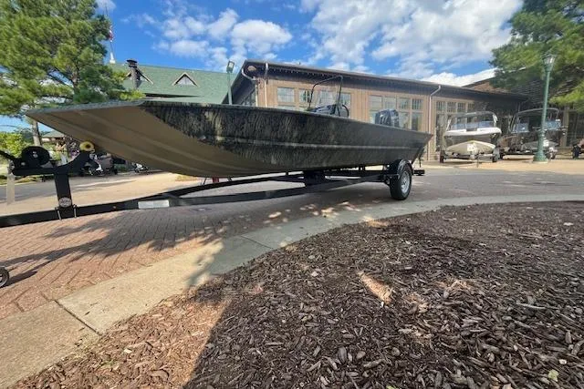 Slide: The Image of 2026 Tracker Grizzly 1860 CC boat on trailer, parked outdoors under blue sky. - 2