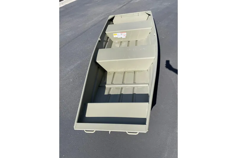 The Image of 2026 Tracker Grizzly 12 Jon boat on pavement, showcasing interior seating and structure. - 0
