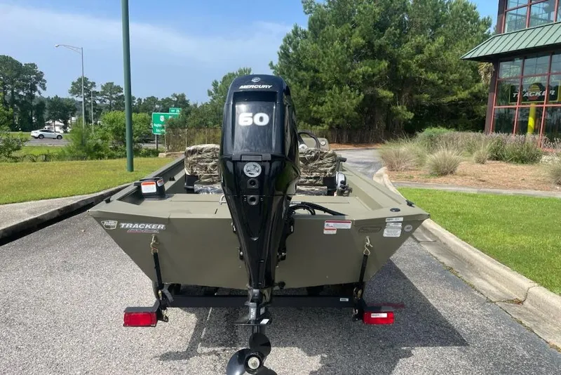 Slide: The Image of 2026 Tracker Grizzly 1754 SC boat with Mercury 60 engine, parked outdoors. - 3