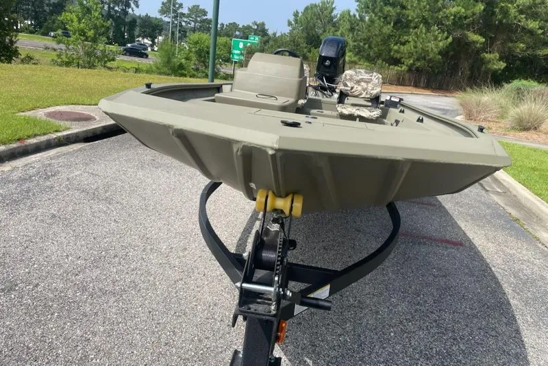 Slide: The Image of 2026 Tracker Grizzly 1754 SC boat on trailer, parked on a road with greenery. - 5