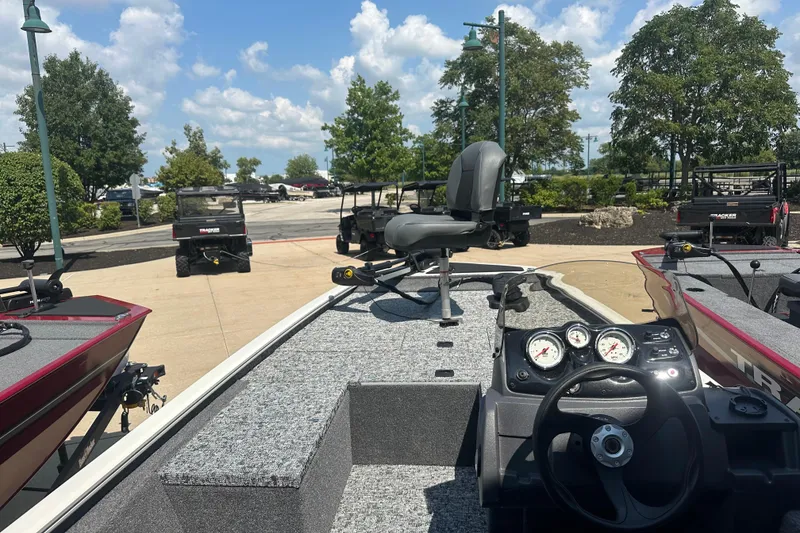 Slide: The Image of 2026 Tracker Pro 170 boat interior with steering wheel and seating, parked outdoors. - 3