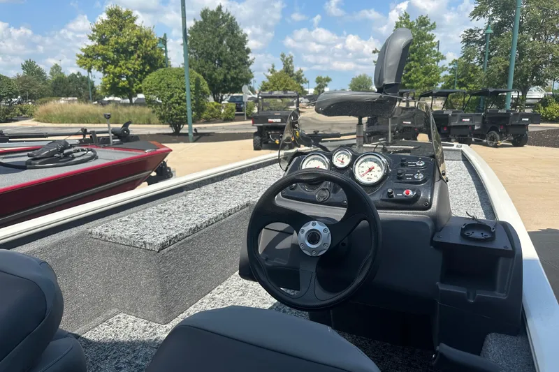 Slide: The Image of 2026 Tracker Pro 170 boat interior with steering wheel and dashboard, parked outdoors. - 4