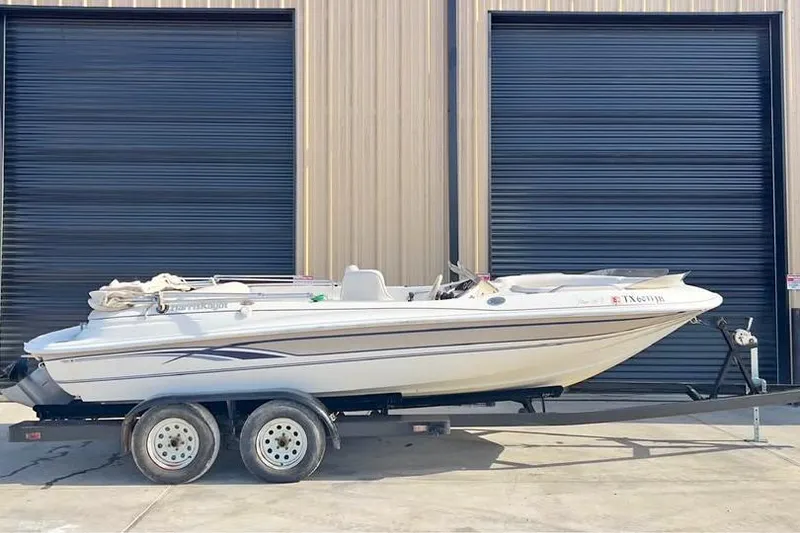 Slide: The Image of 2001 Harris-Kayot Star 20V boat on trailer, parked in front of a building. - 1