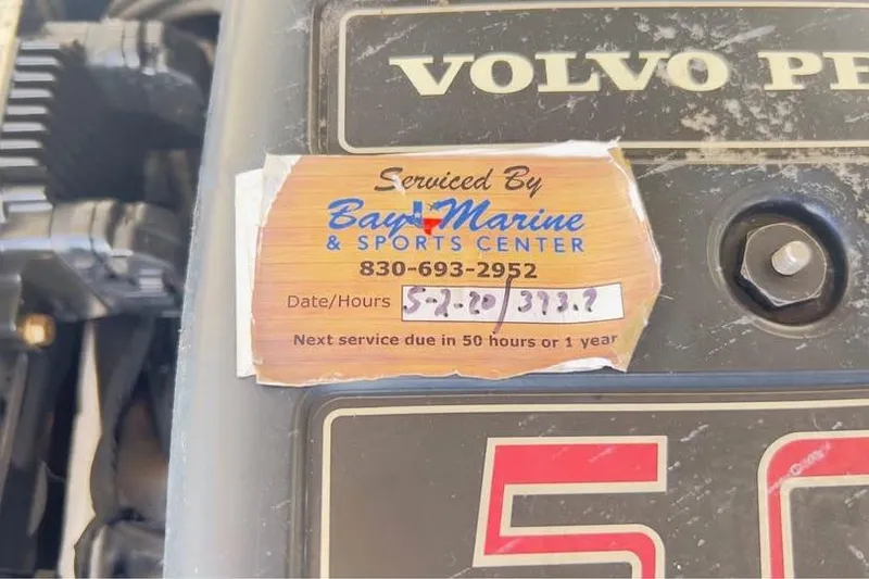Slide: The Image of Sticker on Volvo Penta engine showing service details from Bay Marine & Sports Center. - 13