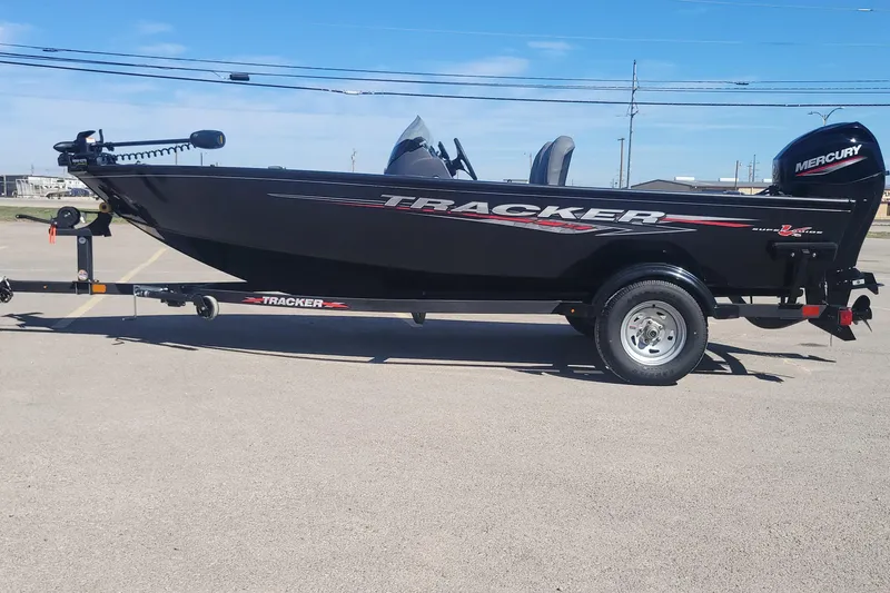 The Image of 2026 Tracker Super Guide V-16 SC boat on trailer, featuring sleek black design and Mercury engine. - 0
