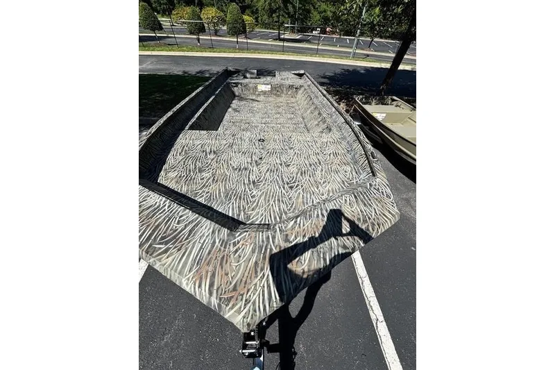 Slide: The Image of 2026 Tracker Grizzly 2072 Utility boat with camouflage pattern in a parking lot. - 2