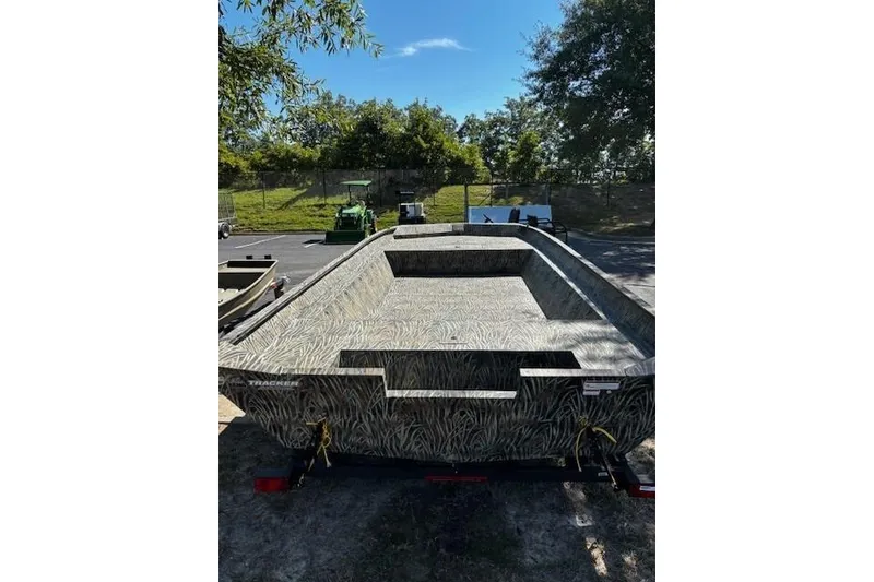 Slide: The Image of 2026 Tracker Grizzly 2072 Utility boat with camouflage design, parked outdoors. - 4