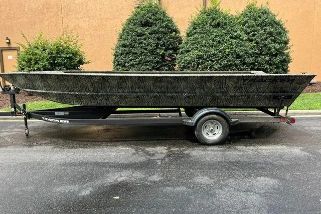 The Image of 2026 Tracker Grizzly 2072 Utility boat on trailer, parked outdoors near greenery. - 0