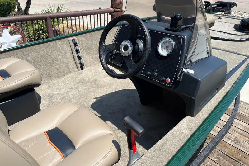 Slide: The Image of 2026 Tracker Bass Tracker Classic Limited boat interior with steering wheel and beige seats. - 7
