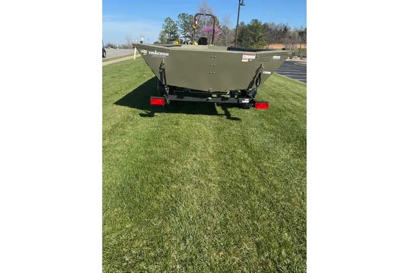 Slide: The Image of 2026 Tracker Grizzly 1754 Utility boat on grass, rear view, sunny day. - 7