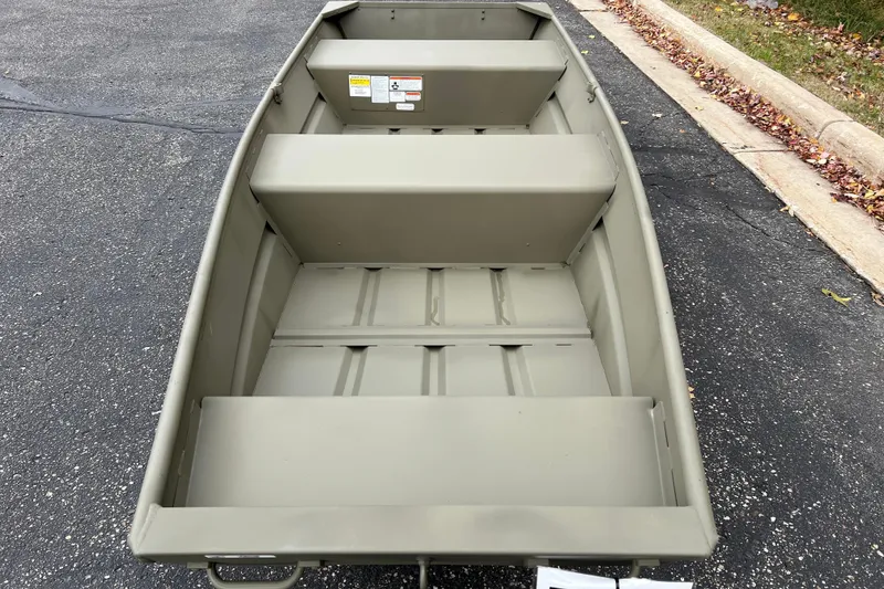 Slide: The Image of 2026 Tracker Grizzly 12 Jon boat on pavement, showcasing interior seating and design. - 33
