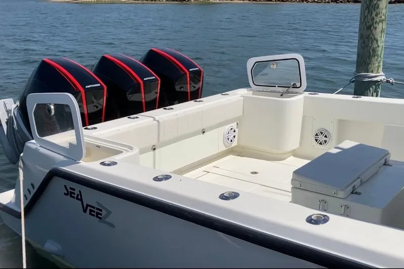 Slide: The Image of 2017 SeaVee 370z boat with triple outboard engines docked on calm water. - 2