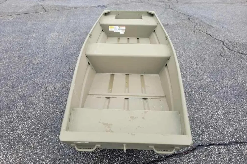 The Image of 2026 Tracker Grizzly 14 Jon boat on asphalt surface, showcasing interior layout. - 0