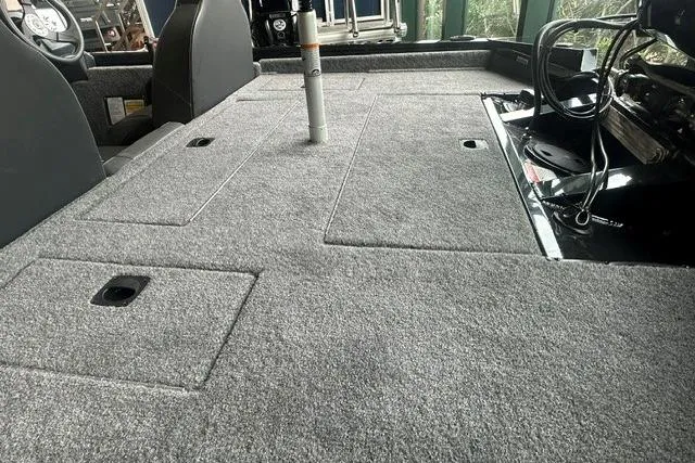 Slide: The Image of 2026 Tracker Pro Team 175 boat interior with gray carpeted deck and storage compartments. - 9