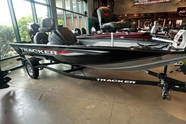 Slide: The Image of 2026 Tracker Pro Team 175 boat displayed indoors, featuring sleek black design and modern seating. - 5